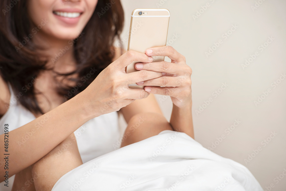Asian woman sitting while using a mobile phone Asian woman sitting while using a mobile phone