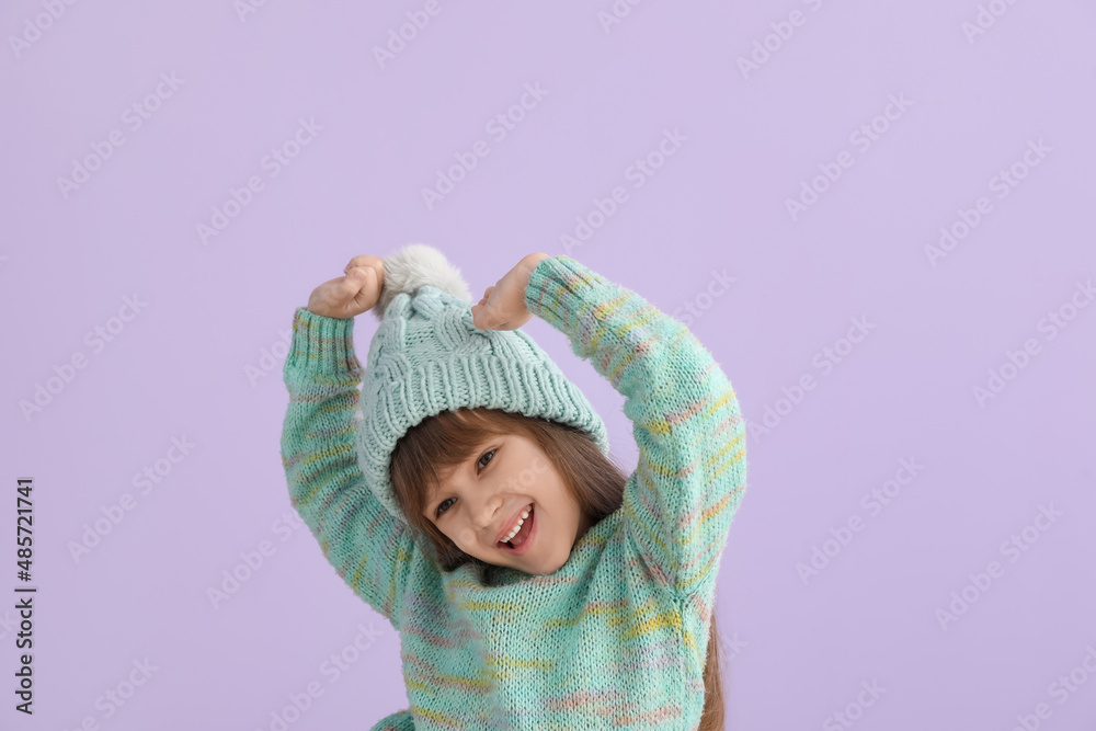 Happy little girl in winter clothes on color background Happy little girl in winter clothes on color background