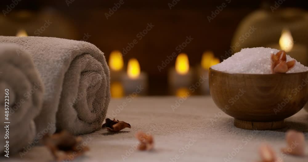 Dried flowers laying on table. Composition of bath salt, hot towels and candle lights on background. Spa, bodycare concept 4k footage