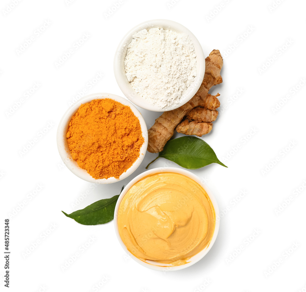 Bowls with turmeric mask and powder on white background Bowls with turmeric mask and powder on white background