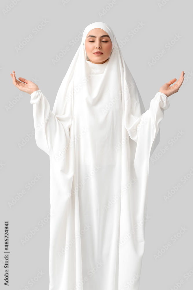 Muslim woman praying on light background Muslim woman praying on light background