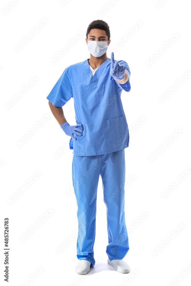 Young African-American doctor in medical mask waggling finger on white background. Immunity concept Young African-American doctor in medical mask waggling finger on white background. Immunity concept