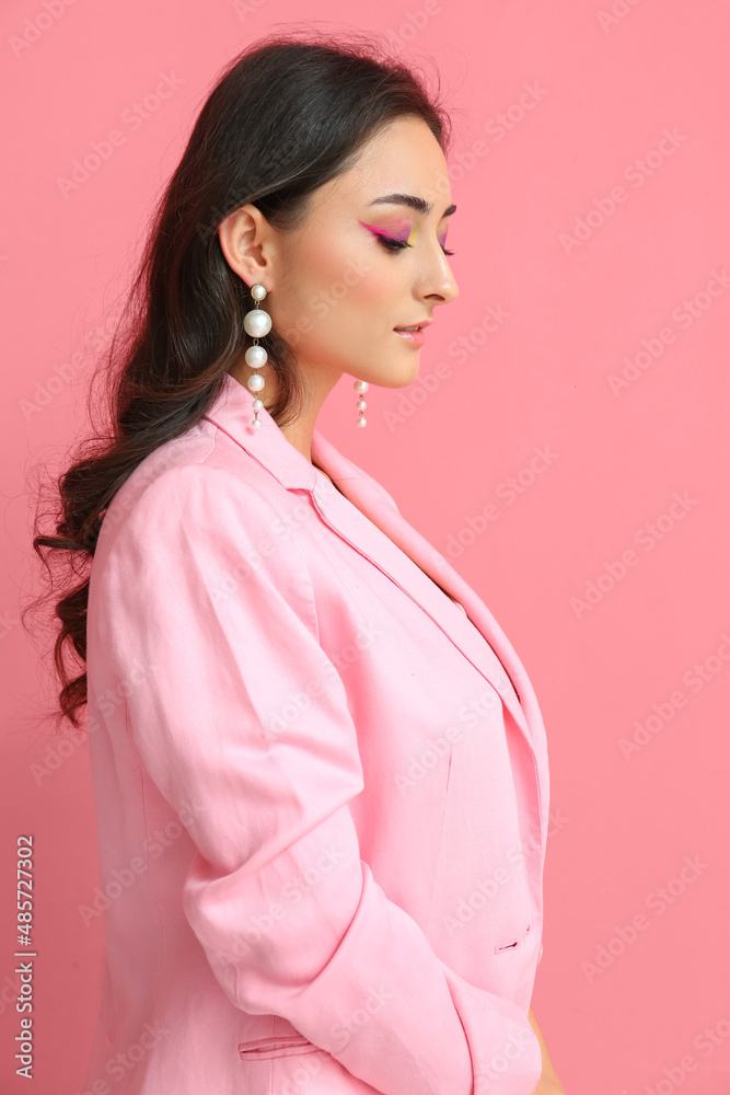 Fashionable woman with creative makeup and stylish jewelry on pink background. International Women's Day Fashionable woman with creative makeup and stylish jewelry on pink background. International Women's Day