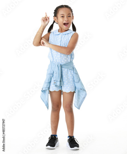 Portrait full body studio cutout shot of Asian young happy cheerful pigtail braid hairstyle elementary school girl in blue sleeveless dress standing posing smiling look at camera on white background