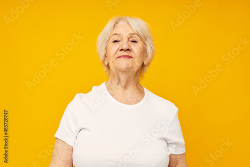 smiling elderly woman in casual t-shirt gestures with his hands close-up emotions