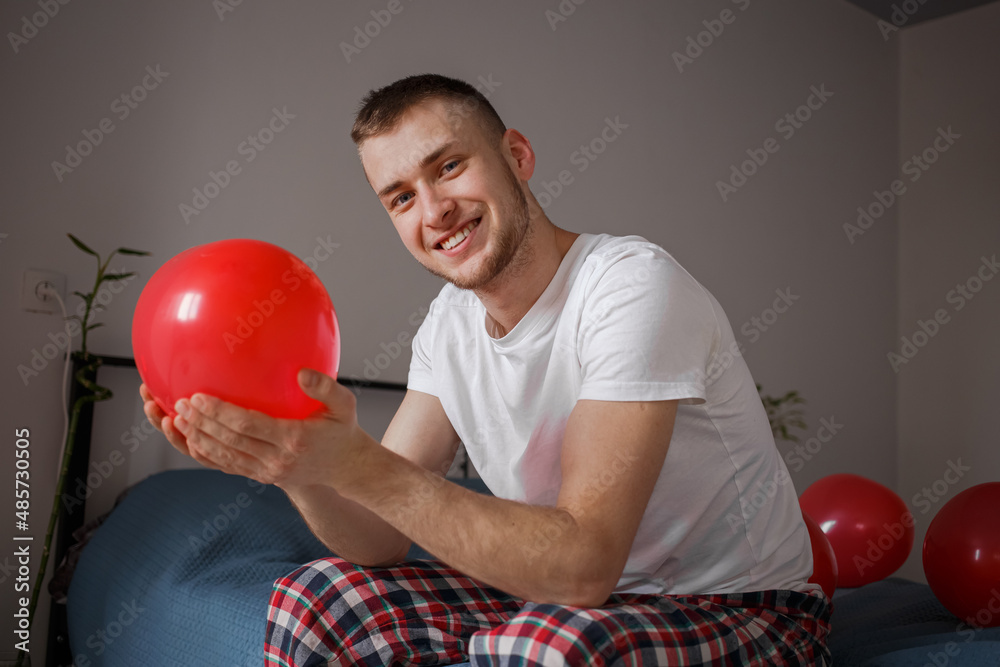 The guy holds a balloon in the form of a heart, for Valentine's Day The guy holds a balloon in the form of a heart, for Valentine's Day