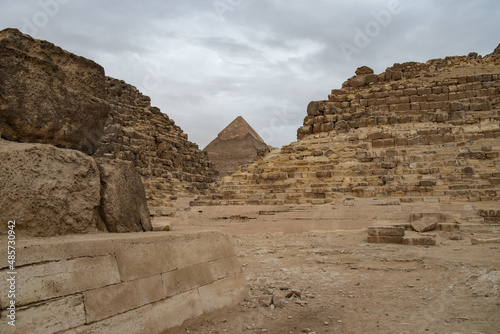 Ruins of the small pyramid of Queen Henutsen with Khafre Pyramids at background  Giza Plateau  Egypt. UNESCO World Heritage