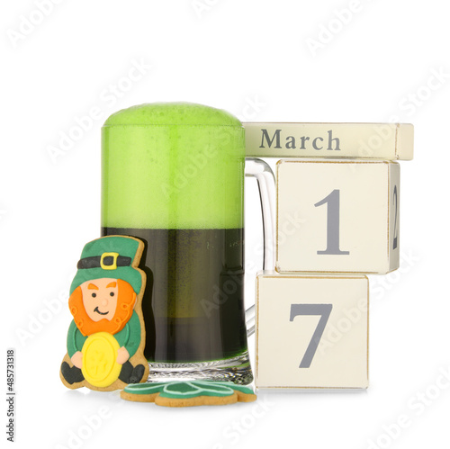 Glass of beer, gingerbread cookie and calendar with date of St. Patrick's Day on white background