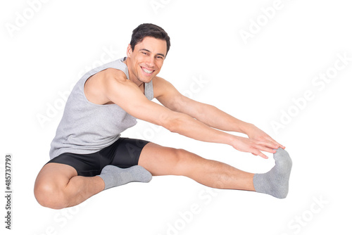 Happy sportsman stretching hamstring muscle in studio