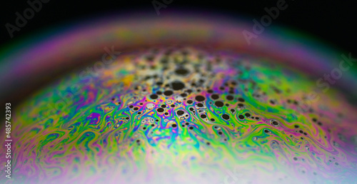 macro shot of a soap bubble. abstract and colorful background. close-up rainbow blurred background. 