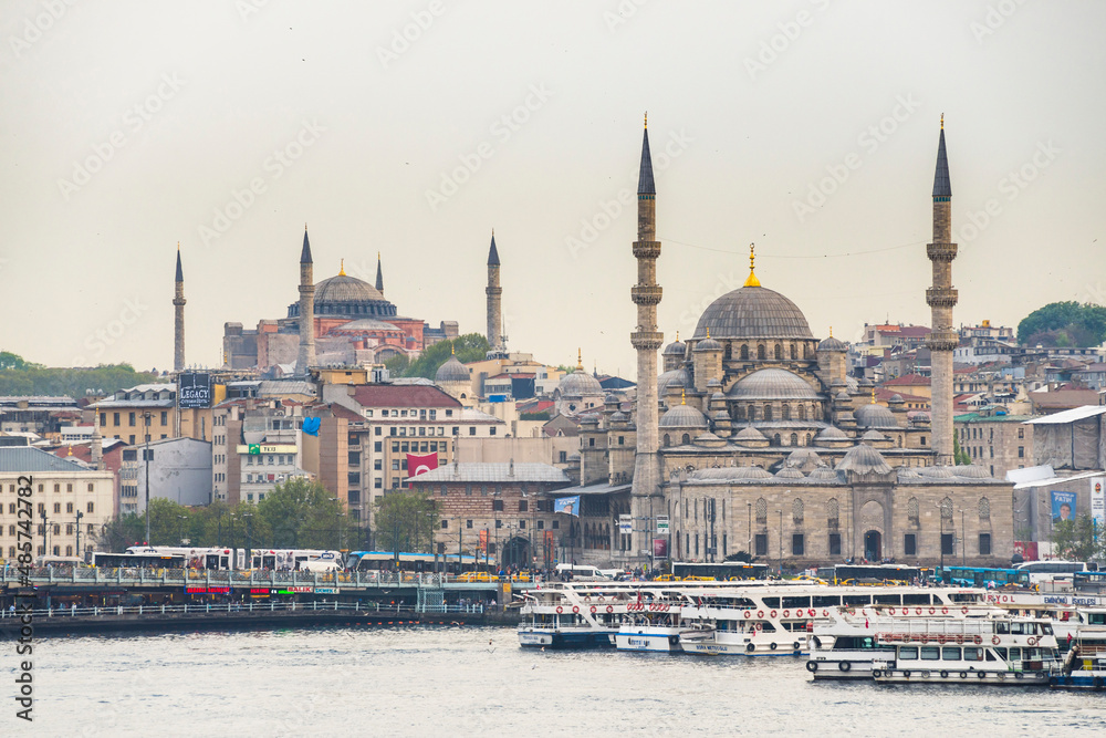 Obraz premium New Mosque (Yeni Cami) at sunset with Hagia Sophia (Aya Sofya) behind seen across the Golden Horn, Istanbul, Turkey, Eastern Europe