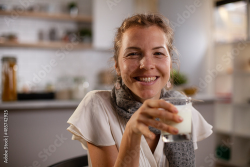 Beautiful businesswoman enjoying in breakfast. Happy young woman eating sandwich at home