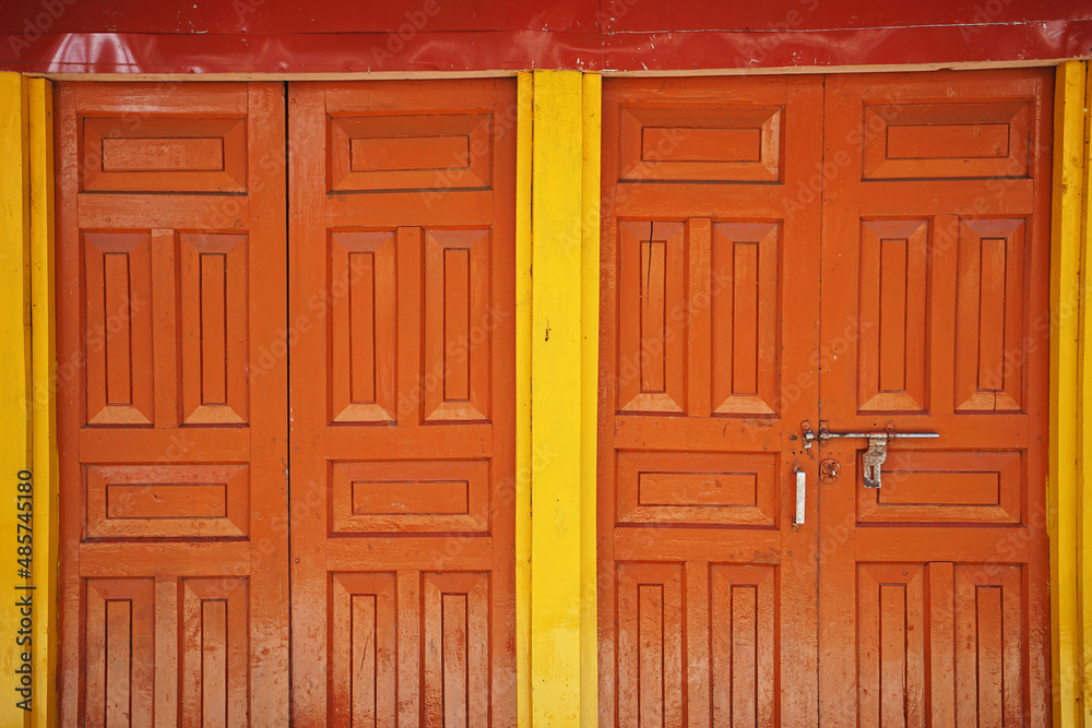 Details and design of ancient wooden orange and yellow door Details and design of ancient wooden orange and yellow door