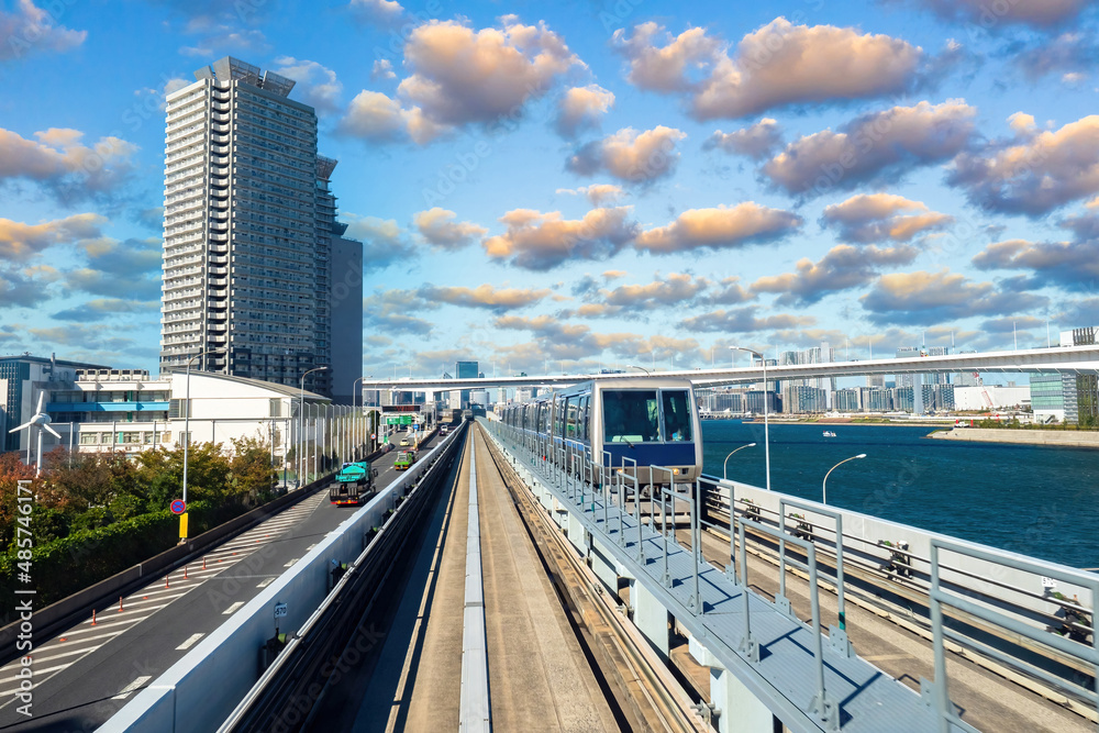 Railroad in Tokyo. High speed train in Japan. Cityscape of Tokyo. High-speed railroad near Tokyo Bay. Road transport infrastructure in Japan. Japanese city on summer day. Overpass for cars and trains