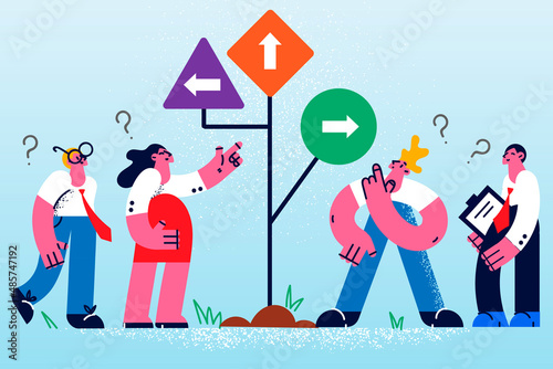 Businesspeople near road sign with different directions 