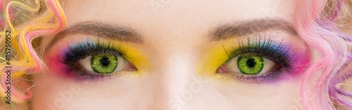 Rainbow multicolor stage makeup for the eyes for parties and discos. Open eye with multicolored shadows on the eyelids. Girl with a professional color make-up. LGBT movement flag colors. Stage makeup.