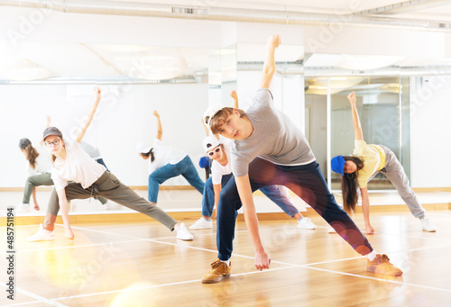 Happy positive teenagers learn dance movements in dance class