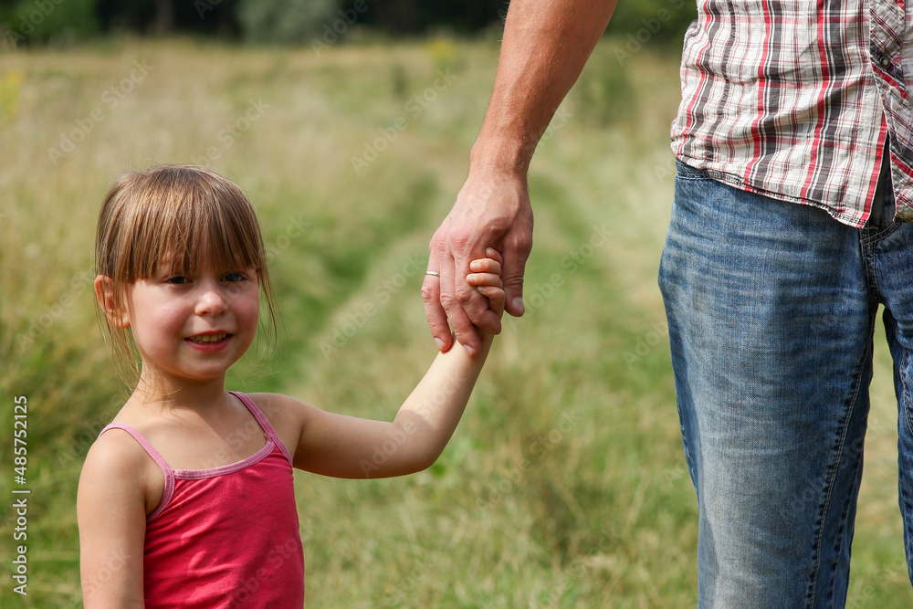 the parent holds the hand of a small child