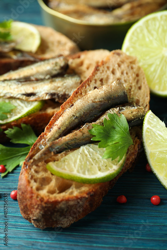 Canvastavla Concept of tasty snack with sandwiches with sprats on wooden background