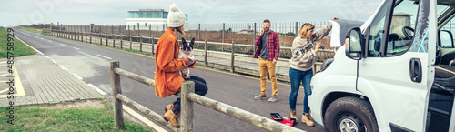 Photos Female mechanic fixing the broken down camper van of a couple going on a trip