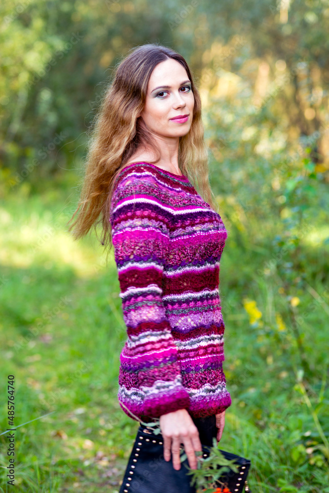 Woman in knitted sweater posing in spring forest
Woman in knitted sweater posing in spring forest