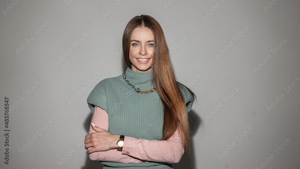 Happy stylish smilies woman with hairstyle in fashion vintage clothes with knitted green vest and pink shirt in studio. Fashionable female portrait Happy stylish smilies woman with hairstyle in fashion vintage clothes with knitted green vest and pink shirt in studio. Fashionable female portrait