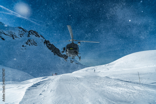 Φωτογραφία Mountain rescue team helicopter rescuing an injured skier after having a skiing