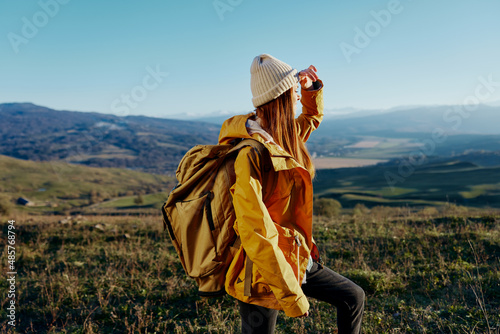 woman tourist in a yellow jacket in a hat backpack travel mountains Lifestyle