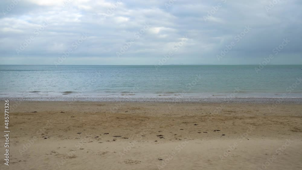 View out to sea from the beach in Swanage, England. Sea and horizon in the distance. Turquoise teal sea and vibrant warm sand in foreground. Peaceful beach 4k scene. View out to sea from the beach in Swanage, England. Sea and horizon in the distance. Turquoise teal sea and vibrant warm sand in foreground. Peaceful beach 4k scene.
