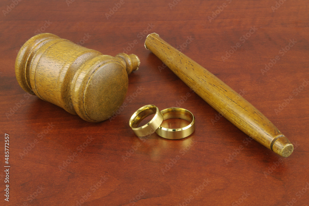 Gold wedding rings and broken judge gavel. Marriage and law concept. Gold wedding rings and broken judge gavel. Marriage and law concept.