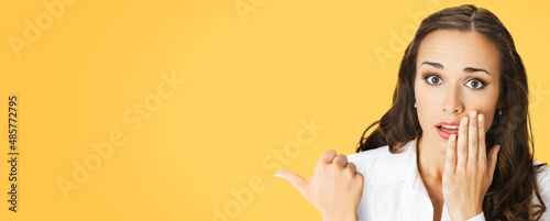 Quadro su tela Portrait image of excited surprised, shocked astonished businesswoman pointing away side with finger