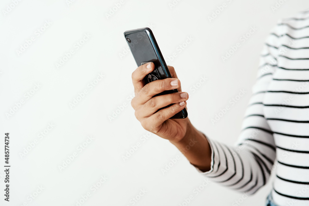 Friends are never far away with your smartphone. Cropped shot of a woman using a smartphone against a white studio background.