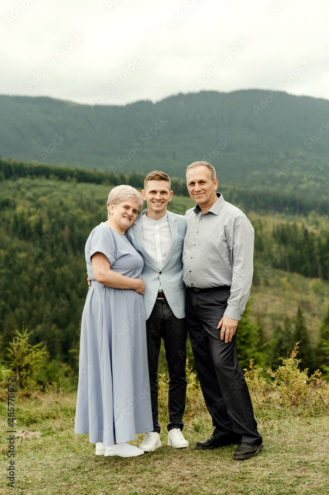 elderly parents with a young wedding couple after a wedding ceremony in the mountains elderly parents with a young wedding couple after a wedding ceremony in the mountains