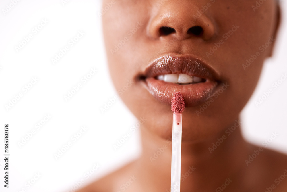 Naklejka premium Glossy lips will never go out of style. Studio shot of an unrecognizable woman applying gloss to her lips.