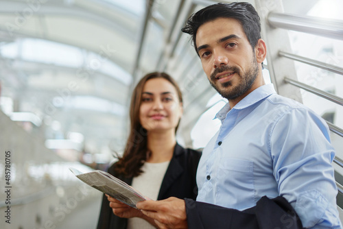 portrait young businessman standing with secretary and newspaper in hand