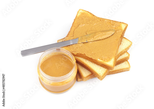 White bread slices with peanut butter spread and table knife isolated on white background