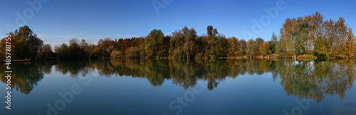 Perfect water reflection of a lake in the autumn, fall. Panorama view.