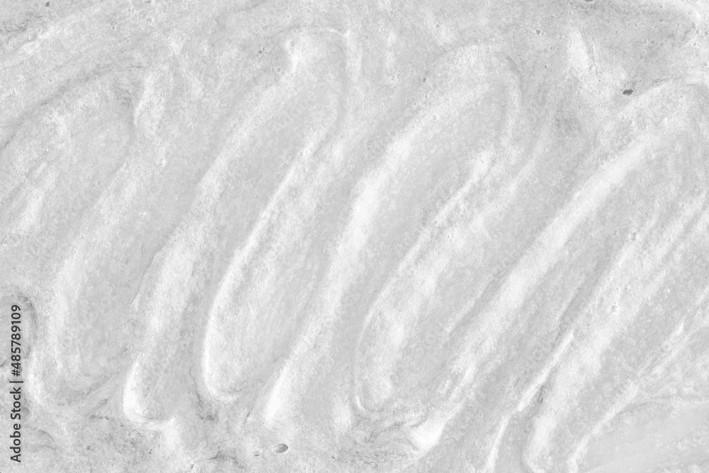 White cream texture. Surface of yogurt and a smoothie of whipped cream smoothie. Background texture of masks and scrubs for face and body. Pearlescent silver surface of the foam. White cream texture. Surface of yogurt and a smoothie of whipped cream smoothie. Background texture of masks and scrubs for face and body. Pearlescent silver surface of the foam.