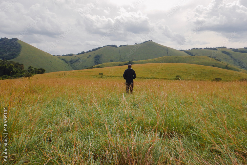 Rear view of a hiker in the panoramic mountains at Chyulu Hills, Chyulu Hills National Park, Kenya Rear view of a hiker in the panoramic mountains at Chyulu Hills, Chyulu Hills National Park, Kenya