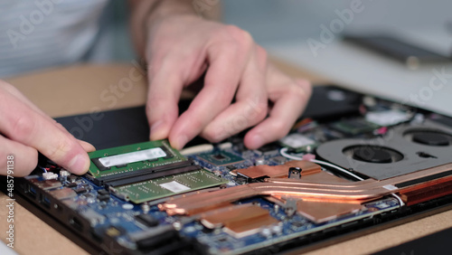 Unrecognizable engineer pulls out the RAM. Electronic renovation, business, occupation concept