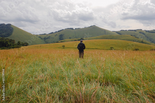 Rear view of a hiker in the panoramic mountains at Chyulu Hills, Chyulu Hills National Park, Kenya