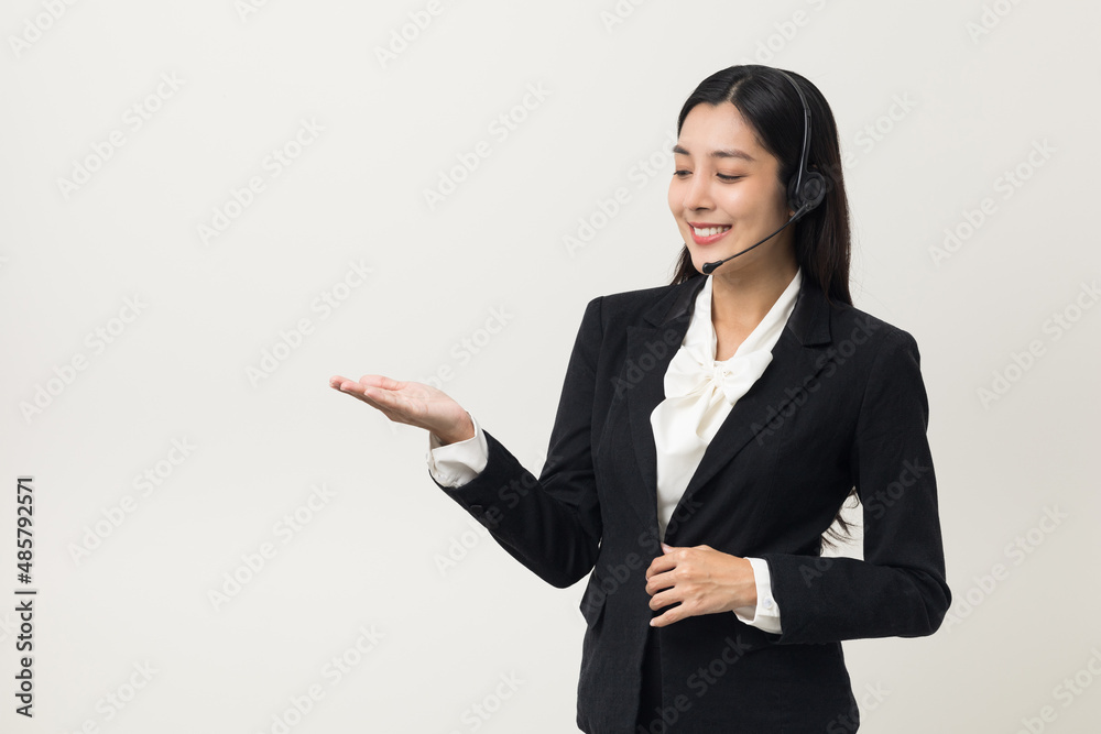 Happy young asian business woman call centre palm up hand to blank space holding something. Welcome female operator put on smalltalk headphone standing on isolated white background. Happy young asian business woman call centre palm up hand to blank space holding something. Welcome female operator put on smalltalk headphone standing on isolated white background.