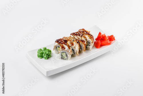 Sushi roll with cucumber, sesame, rice and delicious sauce. Wasabi and ginger on a white background.
