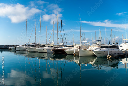 Marina with yachts and boats reflected on the water