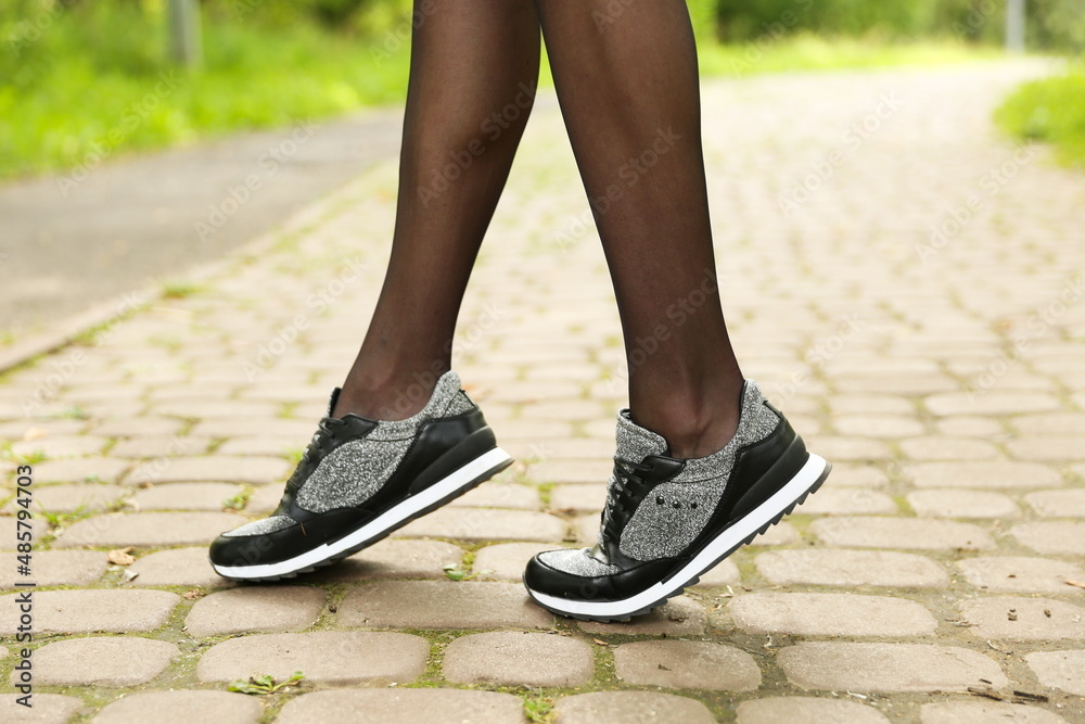 woman's legs wearing sport sneakers outdoors