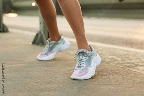 woman s legs wearing sport sneakers outdoors