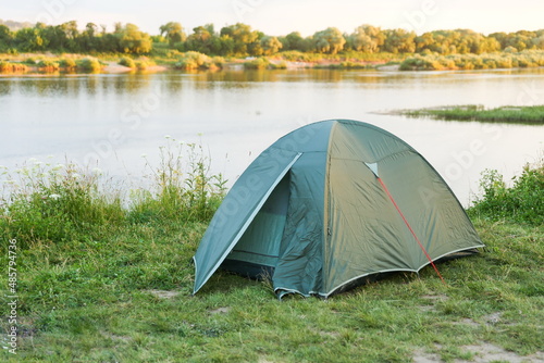 tourist tent is on the bank of the river at sunset