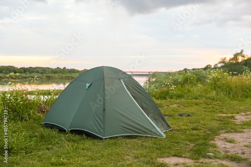 tourist tent is on the bank of the river at sunset