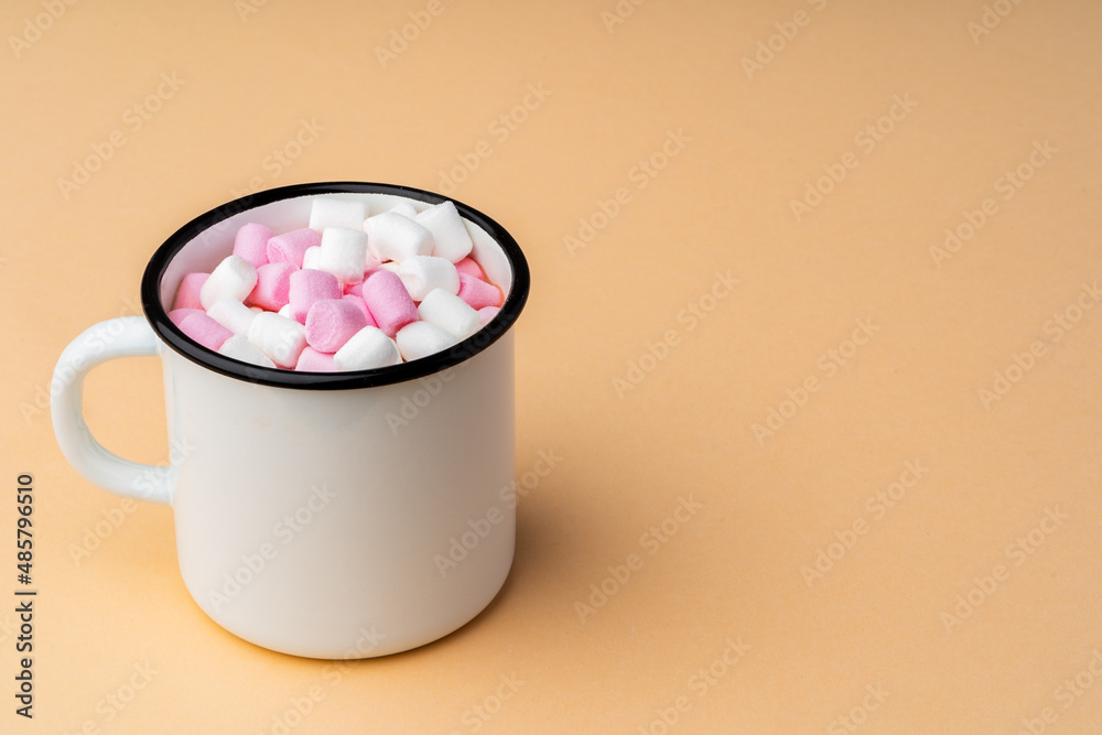 Cup of cocoa with marshmallows on beige background Cup of cocoa with marshmallows on beige background