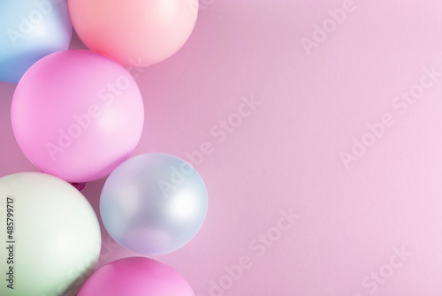 Birthday party, celebration background. Balloons on pastel pink surface. Top view, flat lay, copy space